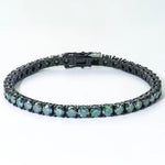 Black metal bracelet with green gemstones on a white background