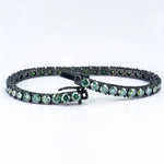 Green gemstone bracelet with black metal clasp on a white background