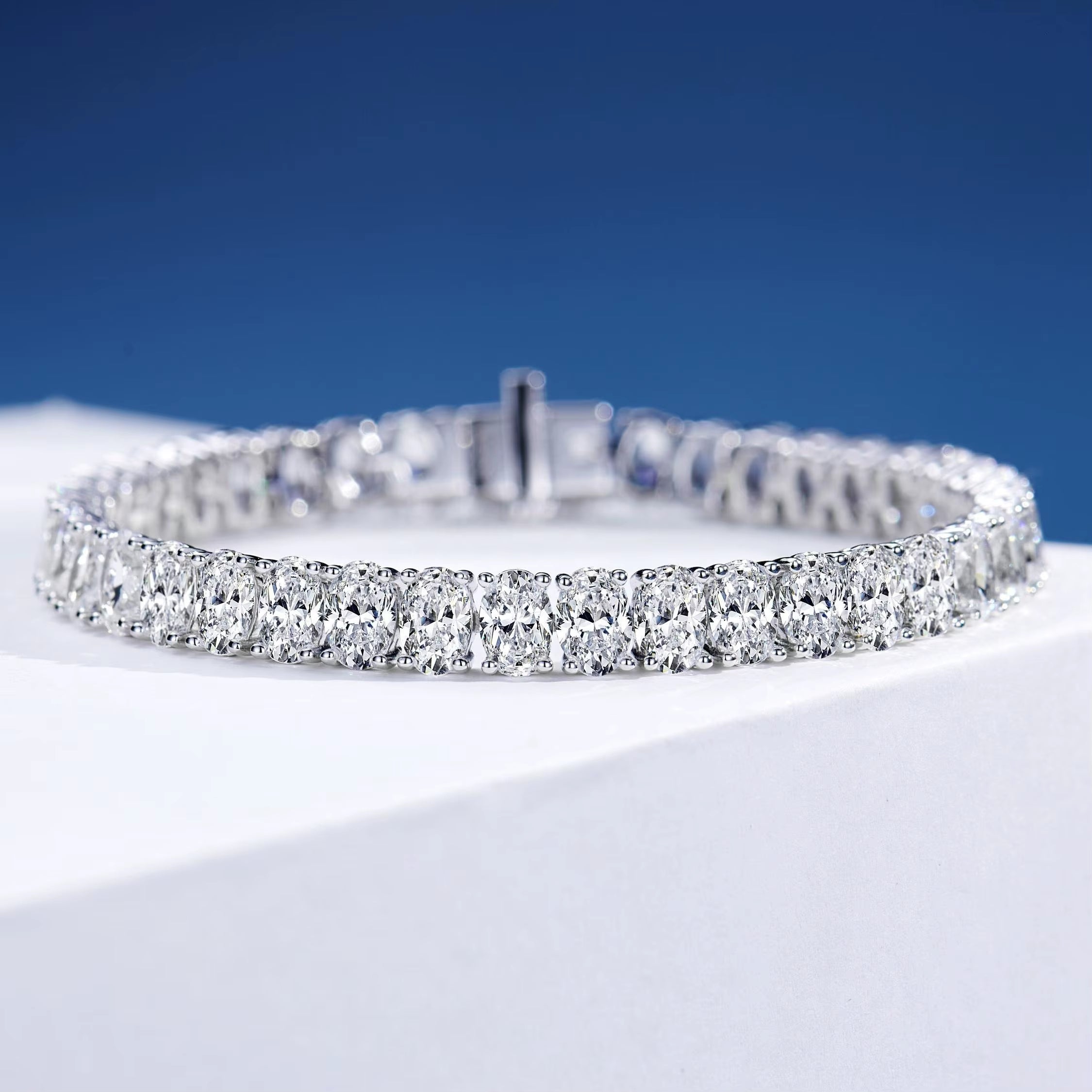 Ice Dazzle Princess cut Tennis Bracelet on a white podium and a blue background